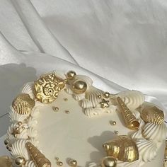 there is a white cake with gold decorations on it