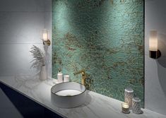 a modern bathroom with green and gold paint on the wall, marble countertop and sink