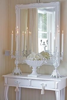 a white dresser with candles on top of it