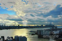 an aerial view of a large city and the ocean with clouds in the sky above it