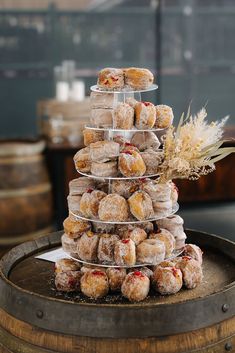 a stack of donuts sitting on top of a wooden barrel