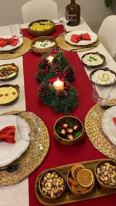 the table is set for christmas dinner with plates and silverware