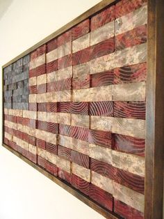 an american flag made out of wood is hanging on the wall