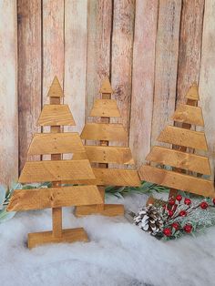 three wooden christmas trees sitting in the snow