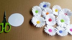 paper flowers are cut out and placed next to scissors