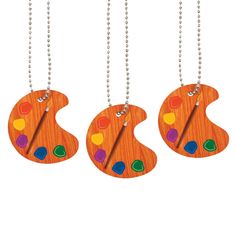 three wooden key chains with colorful designs hanging from it's sides on a white background