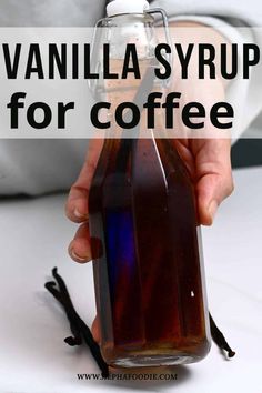 a hand holding a bottle of vanilla syrup for coffee