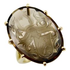 A Kirsten’s Corner Signature piece, we set this Victorian era family crest intaglio into a 14k gold split band ring. The smoky topaz gemstone is faceted along the backside so that when looked at from the top, it sparkles from within. The intaglio carved into the stone is a shield held within a knight’s helmet. The shield has the image of a lion and above the helmet is an elegant scrolling foliate topped with a star. The family crest is unidentified but is rich with heraldic symbolism.   We set the intaglio in a ring with elongated prongs that allow you to see all sides of the stone. The split band gives the ring a great openness and the intaglio can be seen from below, illuminated through the topaz. Ideal as a cocktail ring, the intaglio sits high above the finger, giving this ring a regal Family Crest Ring, Antique Cocktail Ring, Insect Ring, Family Crest Rings, Smoky Topaz, Silver Wings, Gold Signet Ring, Topaz Stone, 14k Gold Ring