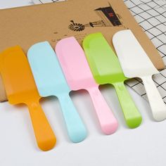 five plastic spatulas sitting on top of a table