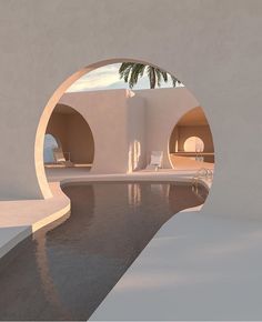 an outdoor swimming pool surrounded by white walls and arches with palm trees in the background