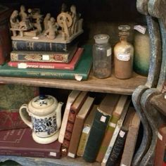 books, jars and figurines are sitting on a shelf