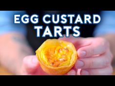 an egg custard tarts is being held by someone's hand with the words, egg custard tarts