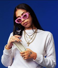 a woman wearing pink sunglasses and holding a book