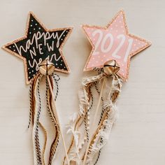 two star shaped cookies with happy new year written on them next to some straws