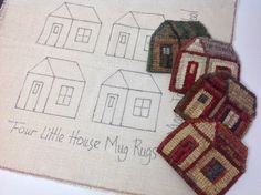 three little houses are on the table next to each other, and there is a small piece of fabric that says four little houses may rugs