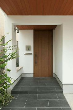 the entrance to a modern home with wood and tile