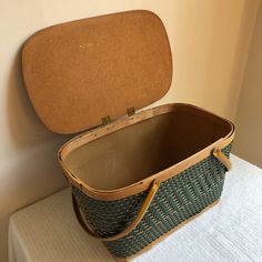 an open suitcase sitting on top of a white table next to a brown box with handles