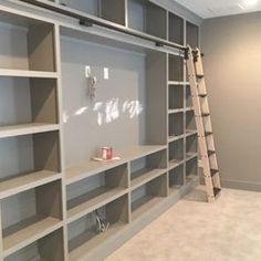 an empty room with shelves and ladders in it