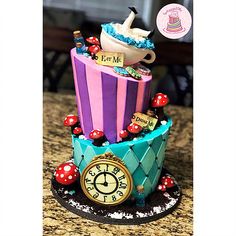 there is a colorful cake with a clock on the top that says it's tea time