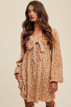 -Color: Gold -Front tied sequin long sleeves dress -Stretched -V-neck with front tie -Long puff sleeves with elastic cuffs -Open back with adjustable tie string Zipper on back waist -Finished with clean hem -Lined -Imported -Content: 97% Polyester 3% Spandex -Model is 5' 7" 31-24-35 and wearing a size Small Sequin Flutter Sleeve Dress, Long Sleeve Mini Dress Lulus, Long Sleeve Formal Dress Short Lulus, Long Sleeve Sequin Fringe Dress, Sequin Dresses Short Long Sleeve, Long Sleeve Tulle Mini Dress, Gold Sequined Dress With Sleeves, Boho Long Sleeve Homecoming Dresses, Sequin Dress With Boots Short