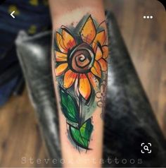 a sunflower tattoo on the arm with green leaves