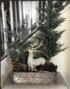 a wooden box filled with pine cones and a deer figurine sitting on top of it