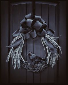 a wreath on the front door is decorated with feathers and leaves, as well as a bird's nest