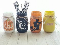 four painted mason jars with halloween decorations on them