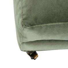 the back end of a green couch with buttons on it's armrests