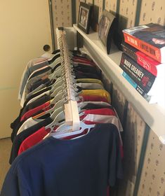 there are many books and shirts on the shelf