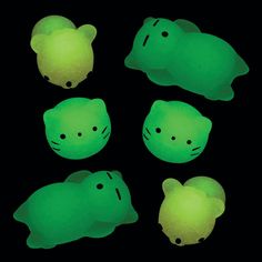 four green cats glow in the dark with their eyes closed and one cat's head turned upside down