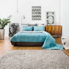 a bedroom with gray walls and blue bedding