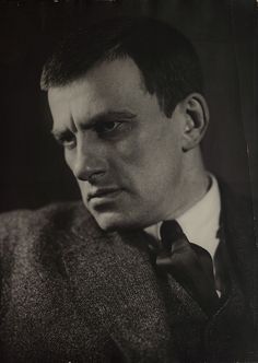 an old photo of a man in a suit and tie looking to the side with his eyes wide open