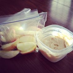 there are some apples in a plastic bag next to a container of yogurt