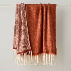 an orange and white blanket hanging on a wall