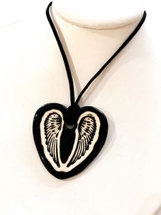 "This is a hand-formed and hand painted ceramic heart with wings necklace made by Surly Amy at Surly-Ramics. This necklace has one of our small size pendants. *PLEASE NOTE I make these in small batches so the necklace you receive may vary slightly from the one in the photo. The color, size and style will be the same but the glaze will settle slightly differently from piece to piece. I have posted some photos of one of my models the beautiful Surly Brooke wearing a similar necklace so you can see Gift Black Jewelry With Wing-shaped Pendant, Wing-shaped Black Jewelry Gift, Black Wing-shaped Jewelry Gift, Wing-shaped Black Jewelry For Gifts, Black Wing-shaped Jewelry For Gifts, Black Heart-shaped Necklace For Keepsake, Black Heart Necklace For Keepsake, Black Heart Necklaces For Keepsake, Hand Painted White Heart Jewelry