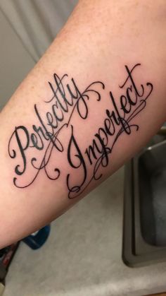 a person with a tattoo on their arm that says perfectly imperfected