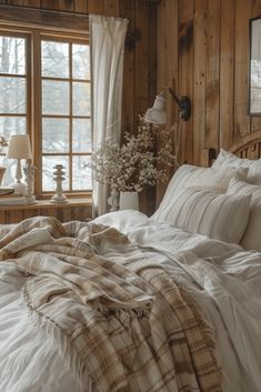 an unmade bed in a room with wood paneled walls and white linens