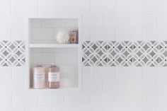 two white shelves with bottles and soaps on them