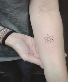 a person with a tattoo on their arm holding the hand of another person's wrist