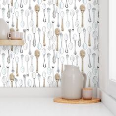 spoons and measuring spoons on a wallpapered kitchen counter