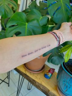 a woman's arm with a tattoo saying slow down, you're doing something right now