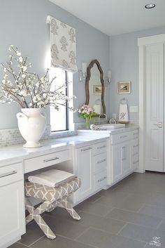 a white bathroom with two sinks and a large mirror on the wall above it's counter