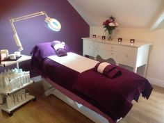 a spa room with purple walls and white furniture