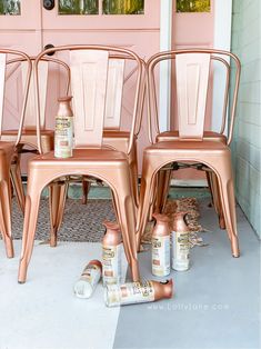 three pink chairs sitting next to each other in front of a door with spray paint on them