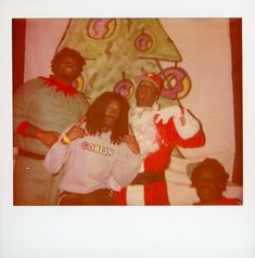 an old photo of three people dressed as santa clause