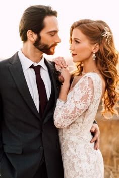 a man in a suit and tie standing next to a woman wearing a wedding dress