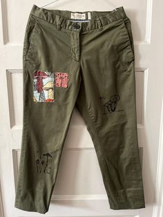 a pair of green pants with patches on them