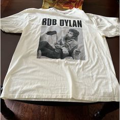 *Bob Dylan Tee Nwt. *Bob's Pic On The Front Nothing On The Back *100% Cotton, Cream Colored Shirt With Black Graphics *Size X Large *I Will Ship Same Day Or Next Day For Late Orders. W/E Orders Go Out Monday Morning Smoke Free Home Pet Free Home Fast Shipping Clean Home Environment Seller Thank You For Looking! B5 Cream Vintage T-shirt With Relaxed Fit, Casual Beige Shirt With Graphic Print, Casual Beige Graphic Print Shirt, Casual Cream Pre-shrunk Tops, Casual Cream T-shirt, Vintage Style Cream Relaxed Fit T-shirt, Cream Vintage Relaxed Fit T-shirt, Cream Vintage Style Relaxed Fit T-shirt, Casual Cream Crew Neck Shirt