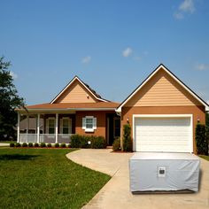 a house with a covered driveway in front of it and two garages on the other side